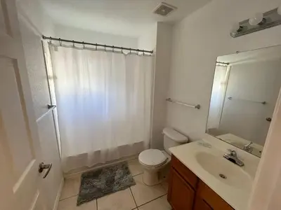 a bathroom with a shower and a toilet and a sink at Renovated 4 bed3 bath Townhome near Disney in Kissimmee