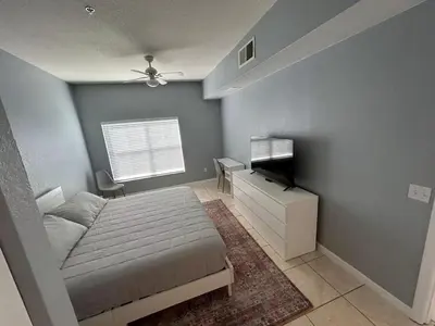 a bedroom with a bed and a television in it at Renovated 4 bed3 bath Townhome near Disney in Kissimmee