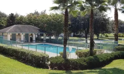 a resort with a swimming pool and palm trees at Villa near Disney Jacuzzi Pool 4bed-3baths in Kissimmee