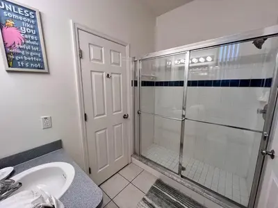a bathroom with a glass shower and a sink at Villa near Disney Jacuzzi Pool 4bed-3baths in Kissimmee
