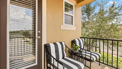 two chairs on a balcony with a window at Upstay Spacious 5BR Villa Private Pool and Hot Tub in Orlando