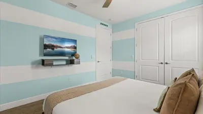 a bedroom with a bed and a tv on a wall at Upstay Spacious 5BR Villa Private Pool and Hot Tub in Orlando