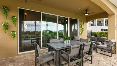 a dining room with a table and chairs on a patio at Upstay Spacious 5BR Villa Private Pool and Hot Tub in Orlando