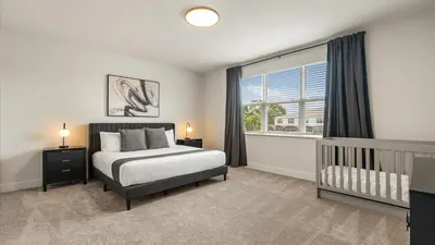 a bedroom with a bed and a crib and a window at Contemporary 4BR Townhome with Pool & Themed Rooms in Orlando