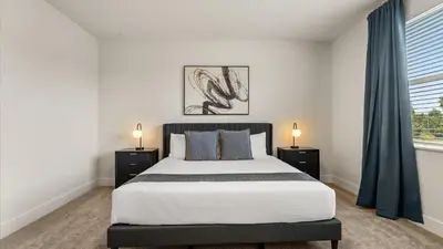 a bedroom with a large bed and two night stands at Contemporary 4BR Townhome with Pool & Themed Rooms in Orlando