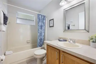 a bathroom with a sink and a toilet and a mirror at 3BR Condo Near Disney, with Clubhouse, Pool and Gym in Kissimmee