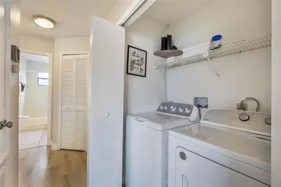 a white laundry room with a washer and dryer at 3BR Condo Near Disney, with Clubhouse, Pool and Gym in Kissimmee