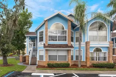 a blue house with a palm tree at 3BR Condo Near Disney, with Clubhouse, Pool and Gym in Kissimmee