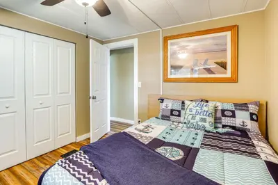 a bedroom with a bed and a painting on the wall at Lakefront Home with Hot Tub and Dock in Orlando! in Orlando