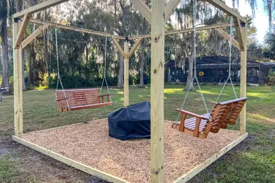 two swings in a gazebo in a park at Lakefront Home with Hot Tub and Dock in Orlando! in Orlando