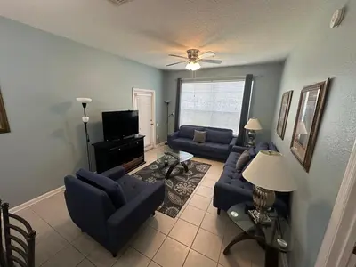 a living room with blue couches and a tv at PalmTree Oasis 3 bedroom Condo at Windsor Hills in Orlando