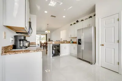 a kitchen with white cabinets and a stainless steel refrigerator at Kissimmee Resort-Style Home Close to Shops and Eats in Kissimmee