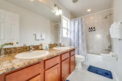 a bathroom with two sinks and a tub and a toilet at Kissimmee Resort-Style Home Close to Shops and Eats in Kissimmee