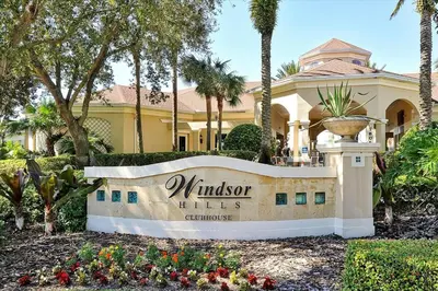 a sign in front of a building with palm trees at 6 Bedroom Villa located in Windsor Hills 3 miles to Disney Free Heated Pool & Spa Game Room with PS5! in Orlando