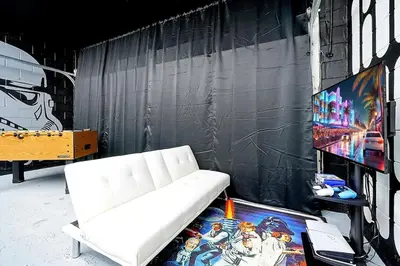 a white couch sitting in front of a wall at 6 Bedroom Villa located in Windsor Hills 3 miles to Disney Free Heated Pool & Spa Game Room with PS5! in Orlando