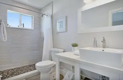 a white bathroom with a sink and a toilet at 24-7 Vacation Club! Affordable Vacation Stays, Multiple Units Available, All Over Florida! Name your price today! in Kissimmee