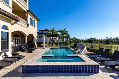 a swimming pool with lounge chairs and a house at 24-7 Vacation Club! Affordable Vacation Stays, Multiple Units Available, All Over Florida! Name your price today! in Kissimmee