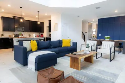 a living room with a blue couch and a kitchen at Storey Lake Resort 515 - Hosted by Top Villas in Kissimmee