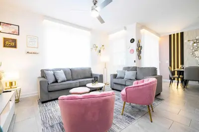 a living room with a couch and pink chairs at Last Minute Disney Private Pool Themed Bedrooms. Book Now SLR516 in Kissimmee