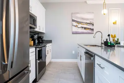 a kitchen with white cabinets and a stainless steel refrigerator at Last Minute Disney Private Pool Themed Bedrooms. Book Now SLR516 in Kissimmee
