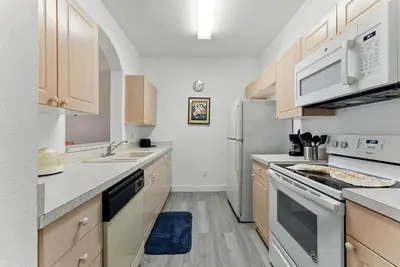 a kitchen with white appliances and wooden cabinets at Last Minute Disney Luxury Condo with Balcony. Book Now WP77 in Orlando