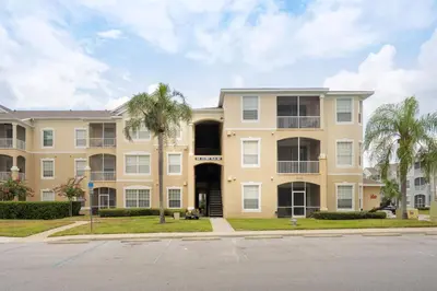 a large apartment building with palm trees in front at Last Minute Disney Luxury Condo with Balcony. Book Now WP77 in Orlando