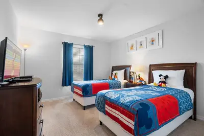 a bedroom with two beds and a desk and a tv at Storey Lake Resort 511 - Hosted by Top Villas in Kissimmee