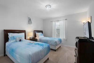 a bedroom with two beds and a flat screen tv at Storey Lake Resort 511 - Hosted by Top Villas in Kissimmee