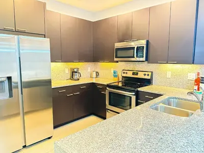 a kitchen with stainless steel appliances and brown cabinets at TR1435RC - 3BR - Sleeps 8 in Orlando