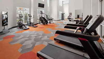 a fitness room with cardio equipment and a man in a gym at Landing Incredible 1BD Gym Clubhouse in Orlando