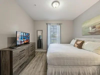 a bedroom with a bed and a flat screen tv at Magnificent 2 Bedroom Apt Vista Cay Resort 107 in Orlando