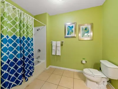 a green bathroom with a toilet and a shower at Magnificent 2 Bedroom Apt Vista Cay Resort 107 in Orlando