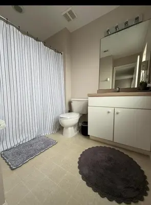 a bathroom with a toilet and a sink and a mirror at Family & Group Haven-Resort Style Living-Near Disney in Kissimmee