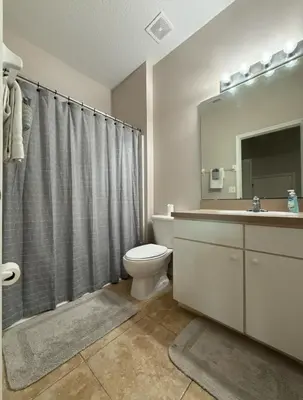 a bathroom with a toilet and a sink and a mirror at Family & Group Haven-Resort Style Living-Near Disney in Kissimmee