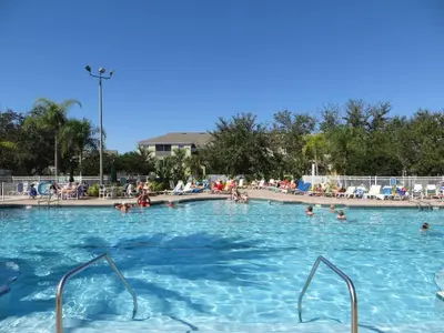 a swimming pool with people in the water at Amazing 3BDR House with pool in Kissimmee