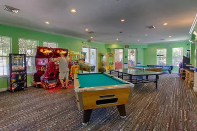 a child playing in a game room with pool tables at Amazing 3BDR House with pool in Kissimmee