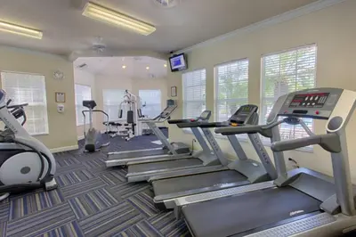 a gym with treadmills and ellipticals in a room at Amazing 3BDR House with pool in Kissimmee