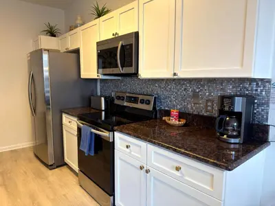 a kitchen with white cabinets and black appliances at The Windsor Hideaway in Orlando