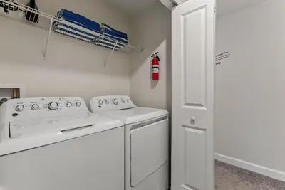 a white laundry room with a washer and dryer at Comfort Stay with Pool Near Attractions in Kissimmee