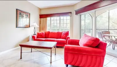 a living room with red furniture and a table at Worldquest Resort Luxurious Pet Friendly Condo in Orlando