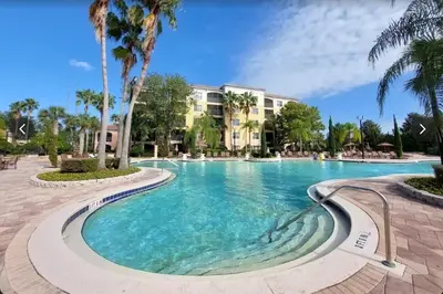 a swimming pool at a resort with palm trees at Worldquest Resort Luxurious Pet Friendly Condo in Orlando
