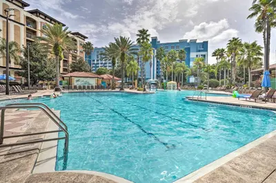 a large swimming pool with palm trees and buildings at Poolside Bliss and Theme Park Thrills Orlando Oasis in Orlando