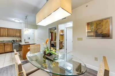 a kitchen and dining room with a glass table and chairs at Poolside Bliss and Theme Park Thrills Orlando Oasis in Orlando