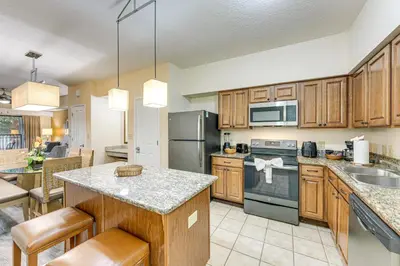 a kitchen with wooden cabinets and stainless steel appliances at Poolside Bliss and Theme Park Thrills Orlando Oasis in Orlando