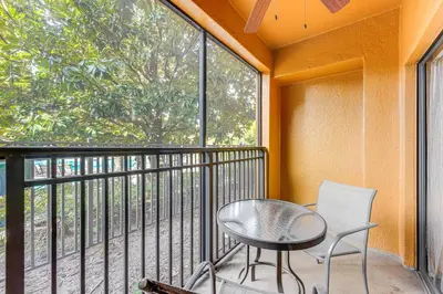 a balcony with a table and chairs and a window at Poolside Bliss and Theme Park Thrills Orlando Oasis in Orlando