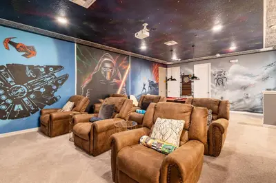 a room with brown chairs and a wall with a mural at Sleeps 36 | 15 Bedroom! Theater! Resort! POOL! in Kissimmee