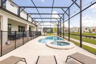 a patio with a swimming pool and a building at Sleeps 36 | 15 Bedroom! Theater! Resort! POOL! in Kissimmee
