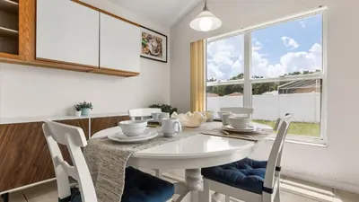 a dining room with a white table and chairs at Upstay 3BR Family-Friendly Stylish Retreat w Patio in Kissimmee