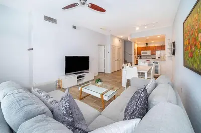 a living room with a couch and a table and a tv at Charming 3BrTownhome near Disney in Kissimmee