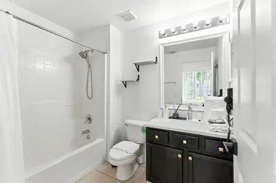 a white bathroom with a sink and a toilet at Casa térrea c/ piscina e 2 suítes, sem carpete in Kissimmee